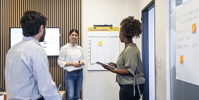 Lluvia de ideas en equipo con Post-it® Bloc de Reuniones y Notas Post-it® en una sala de reuniones
