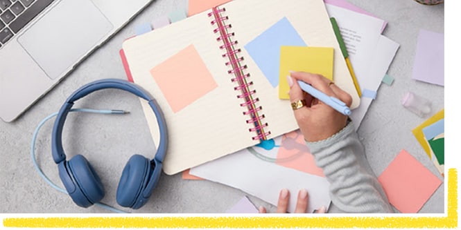 Estudiante tomando notas en una nota Post-it® amarilla
